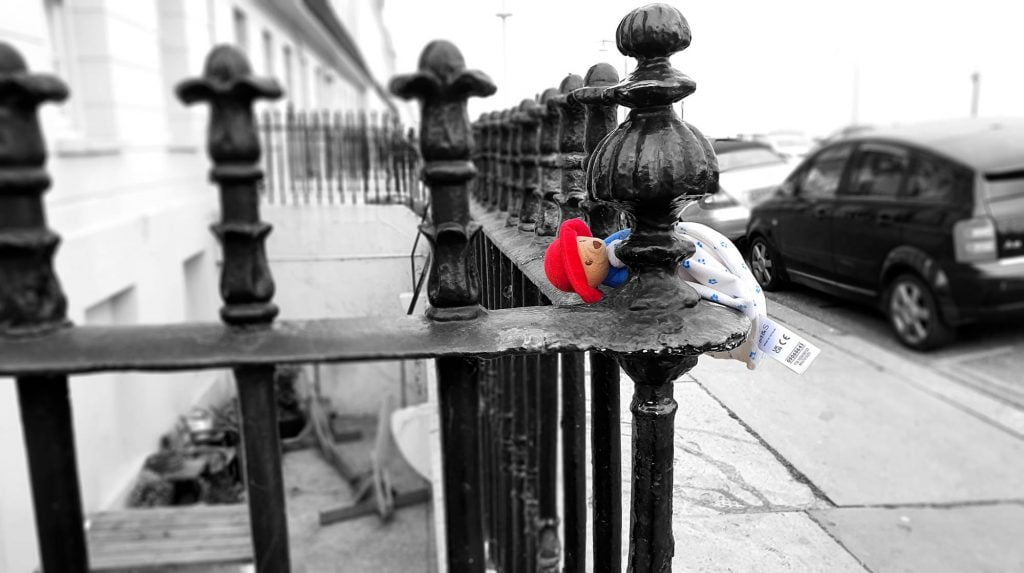 Paddinton Bear left on the railings. Hove, Sussex
